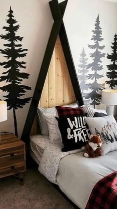 a bedroom decorated in black and white with trees on the wall