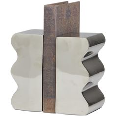 A small piece of decor that make a big difference to give your home an instance refresh. Give your surface space a finishing touch with these beautifully crafted bookends. Give your surface space a playful look with these bookends, either holding books in pace, or used simply as a unique sculpture. Designed with felt or rubber stoppers at the base that prevent scratching furniture and table tops, as well as sliding around. This item ships in 1 carton. Aluminum bookends make a great gift for any occasion. Suitable for indoor use only. This item ships fully assembled in one piece. Made in India. This silver colored non skid bookends comes as a set of 2. Contemporary style. The Novogratz 2-Pack Silver Aluminum Modern Decorative Bookends | 820401 Unique Bookends, Book Display Stand, Decorative Bookends, Contemporary Books, Unique Sculptures, Table Tops, Joss And Main, Shelf Decor, Aluminum Metal