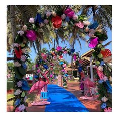 an archway decorated with pink, blue and white flowers in the shape of flamingos