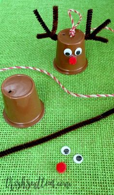 some brown paper cups with googly eyes and nose decorations on green tablecloths