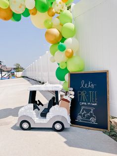 a golf cart with balloons attached to it and a sign that says let's party