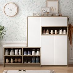 a white cabinet filled with lots of shoes next to a clock