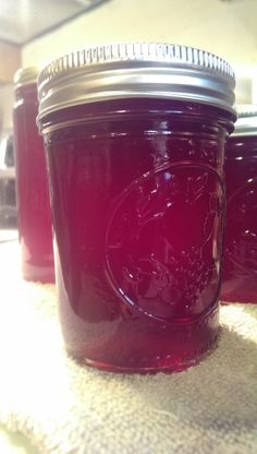 three jars filled with red liquid sitting on top of a table