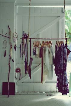 there are many different items hanging on the clothes rack in front of the door,