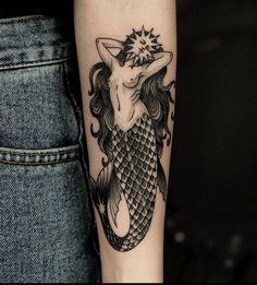 a woman's arm with a black and white tattoo design on the left forearm