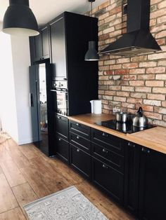 a kitchen with brick walls and black cabinets