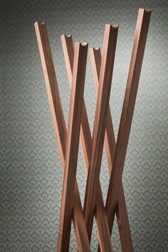 three wooden sticks sticking out of the ground in front of a wallpapered background