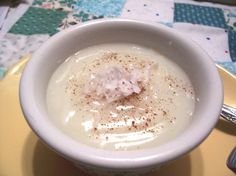 a white bowl filled with cream on top of a yellow plate