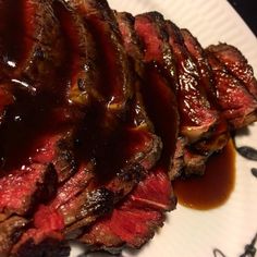 a plate with steak covered in sauce on it