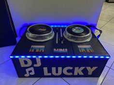 two turntables sitting on top of a blue box with lights around the sides