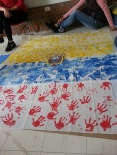 two people sitting on the floor with handprints