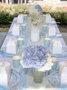 the table is set with blue and white flowers