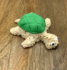 a green turtle made out of oatmeal on top of a wooden table