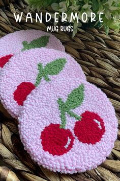 two crocheted coasters with cherries on them