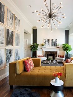 a living room filled with lots of furniture and paintings on the wall next to a fire place