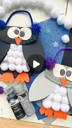 two penguins made out of construction paper and pom poms