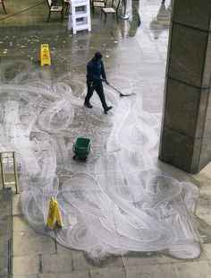 a man with a broom is cleaning the sidewalk