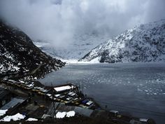 the mountains are covered in snow and clouds