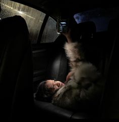 a man laying in the back seat of a car