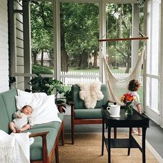 two young children sitting in chairs on a porch with hammock hanging from the ceiling