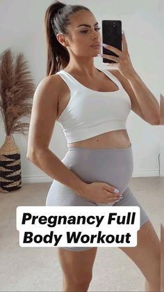 a pregnant woman is taking a selfie with her cell phone while wearing grey shorts