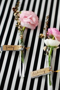 three small vases with flowers in them sitting on a striped tablecloth that says sandy