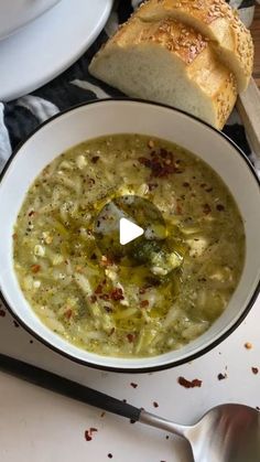 a bowl of soup with bread on the side