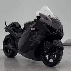 a black motorcycle parked on top of a cement floor