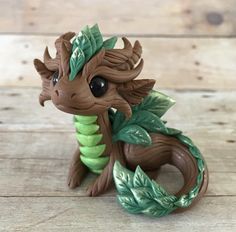 a small toy dragon sitting on top of a wooden floor