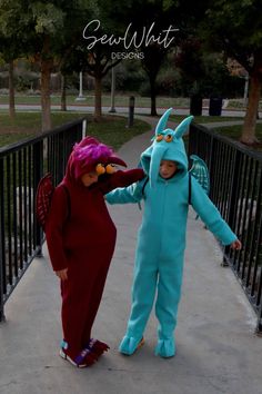 two children dressed in costumes walking down a sidewalk