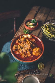 a bowl filled with food sitting on top of a wooden table next to other dishes