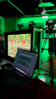 a laptop computer sitting on top of a desk next to a camera and video equipment