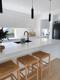 the kitchen counter is clean and ready to be used for cooking or baking, with four stools in front of it