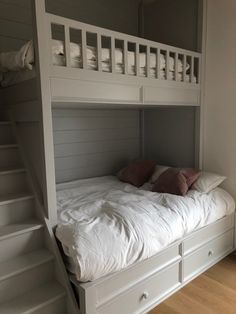 a white bunk bed with drawers underneath it