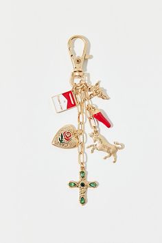 a gold keychain with charms on it, including a cross and other items