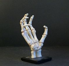 a fake hand is shown on top of a black base and it appears to be holding something in the air