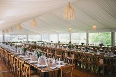 a large tent with tables and chairs set up for a formal dinner or wedding reception