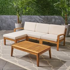 a couch and table on a patio with potted plants in the backgroud