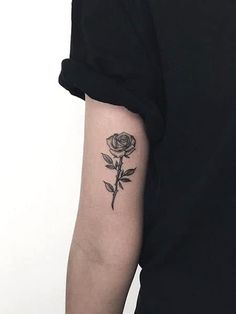 a black rose tattoo on the left arm