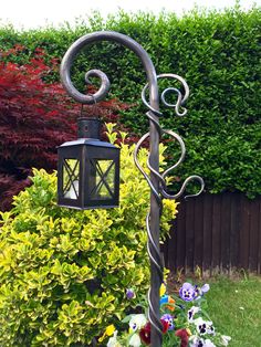 a lamp post in the middle of a garden