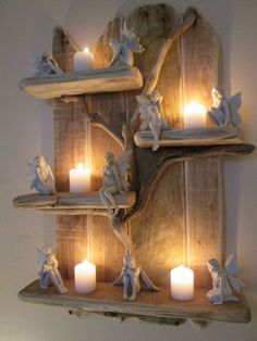 three shelves with candles and angel figurines on them