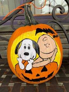 a pumpkin decorated with a charlie the snoopy and jack - o'- lantern