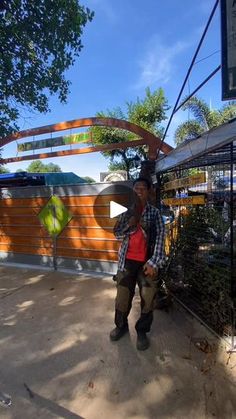 a man standing next to a metal fence