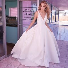 a woman in a white dress is posing for the camera