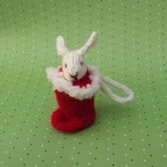 a stuffed animal in a knitted christmas stocking on a green tablecloth with polka dots