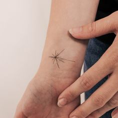 a person with a small star tattoo on their left wrist and the other hand behind her