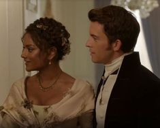 the man and woman are dressed up in period costumes, looking into each other's eyes