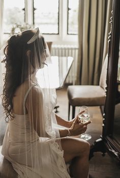 a woman in a wedding dress holding a glass of wine