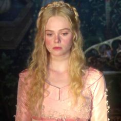 a woman with long blonde hair wearing a pink dress