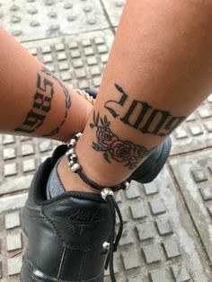 a person with two tattoos on their legs and one has a rose tattoo on her leg